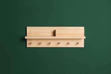 Photo of Wooden hanger for keys on green wall