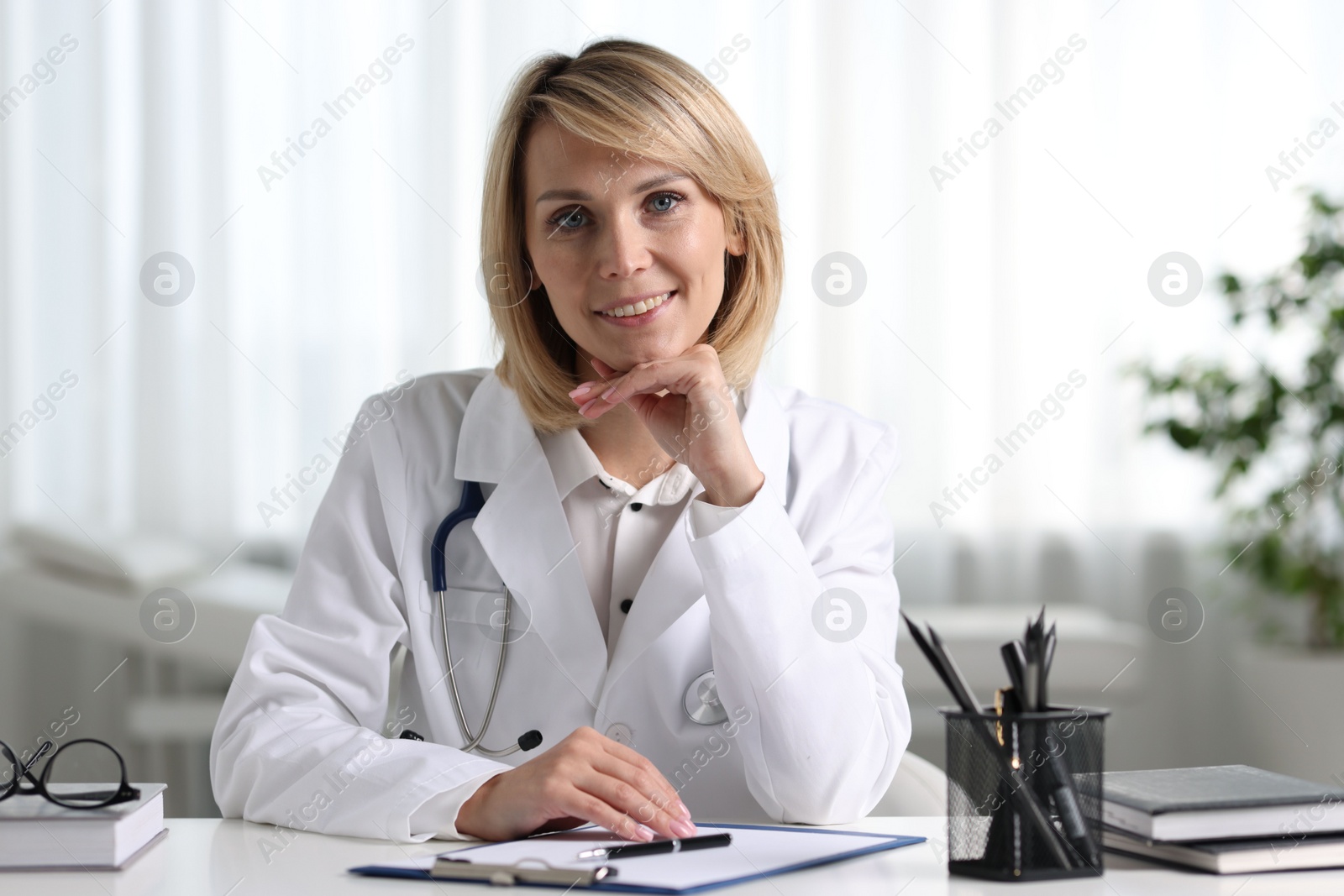 Photo of Portrait of smiling doctor at table in office