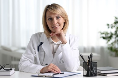 Photo of Portrait of smiling doctor at table in office