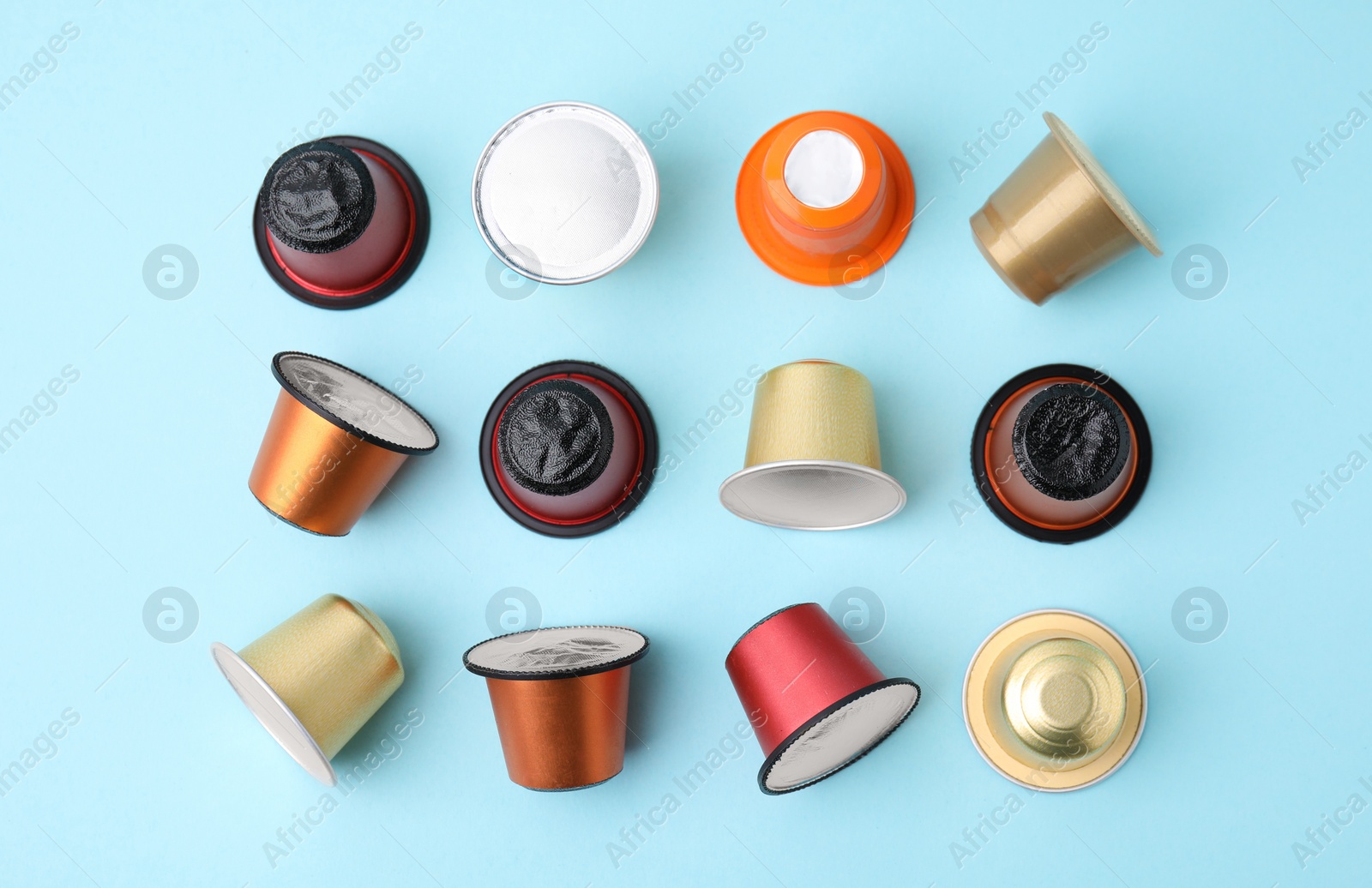 Photo of Many coffee capsules on light blue background, flat lay