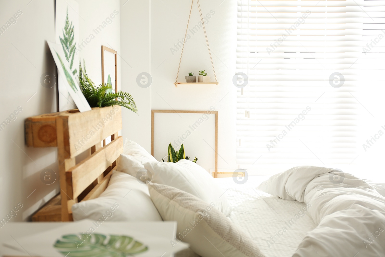 Photo of Stylish room interior with bed and floral pictures