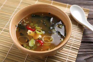 Photo of Bowl of delicious miso soup with tofu on wooden table, closeup