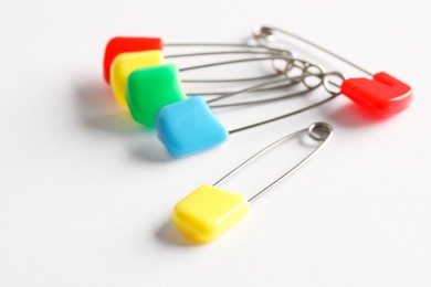 Colorful safety pins on white background, closeup