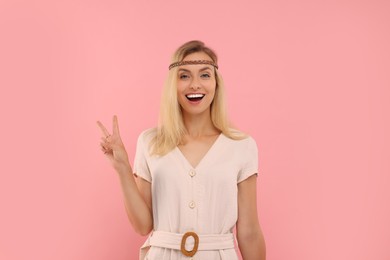 Photo of Portraithappy hippie woman showing peace sign on pink background