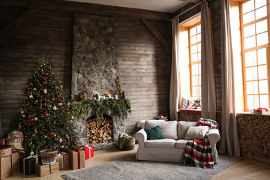 Photo of Festive interior with decorated Christmas tree and fireplace