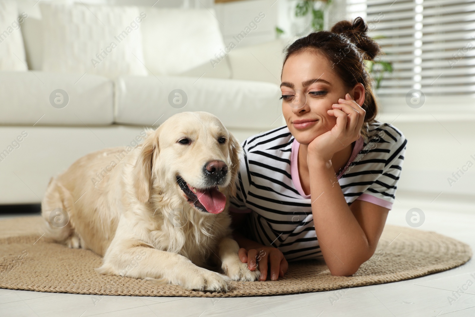 Photo of Young woman and her Golden Retriever at home. Adorable pet