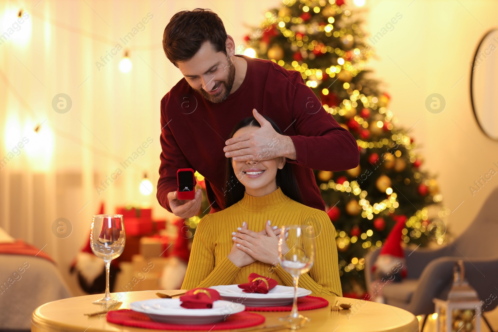 Photo of Making proposal. Man with engagement ring surprising his girlfriend at home on Christmas