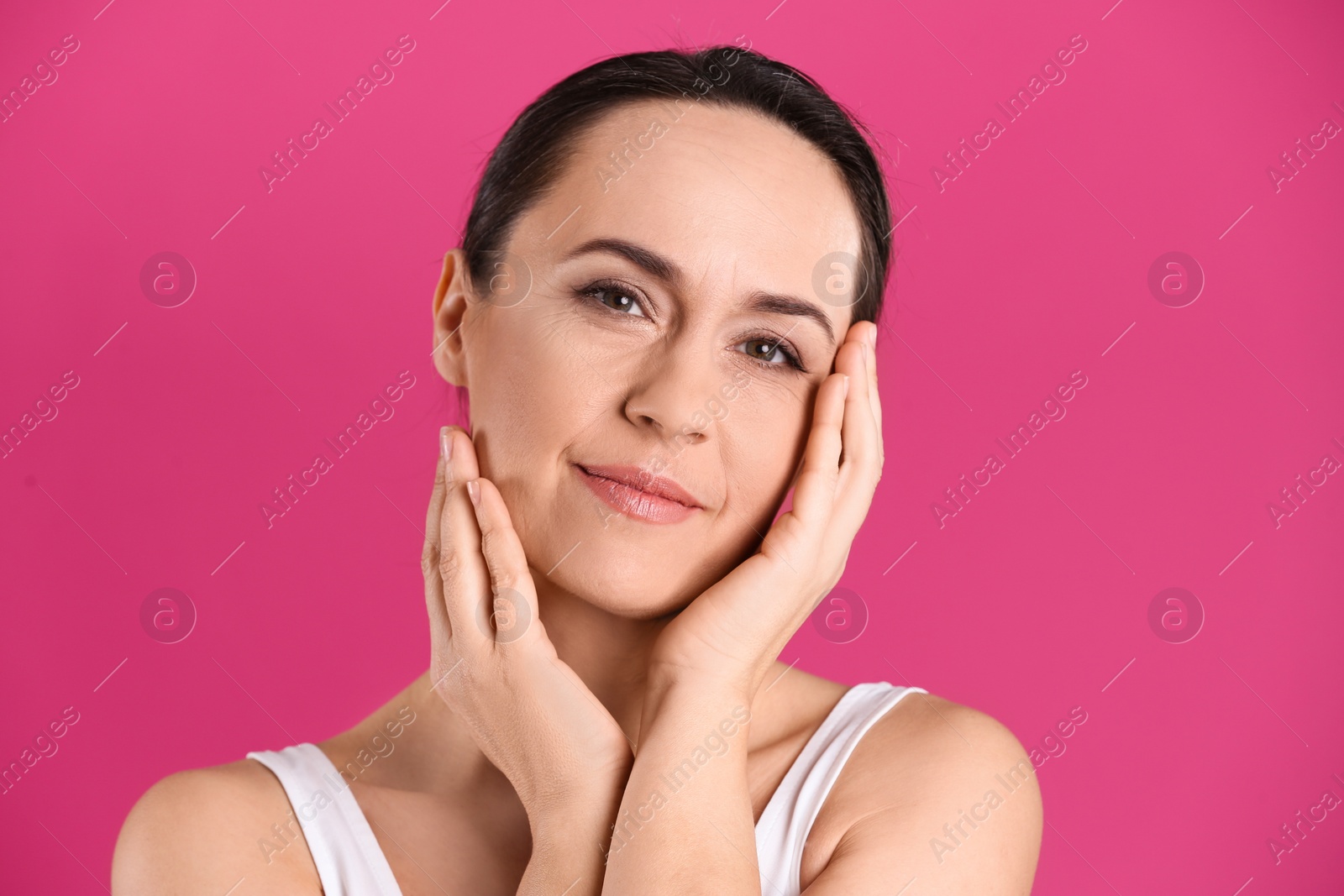 Photo of Portrait of beautiful mature woman on pink background