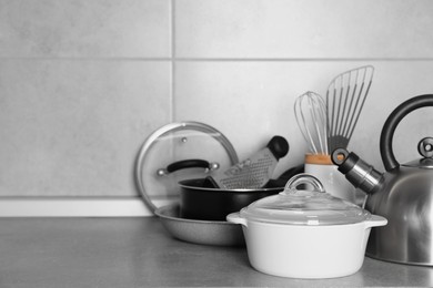 Photo of Cooking utensils and other kitchenware on grey countertop. Space for text