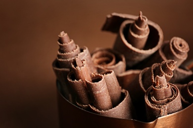 Photo of Pan with chocolate curls on color background, closeup