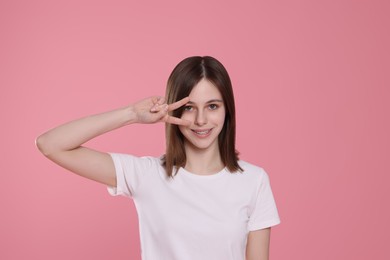 Photo of Portrait of cute teenage girl on pink background