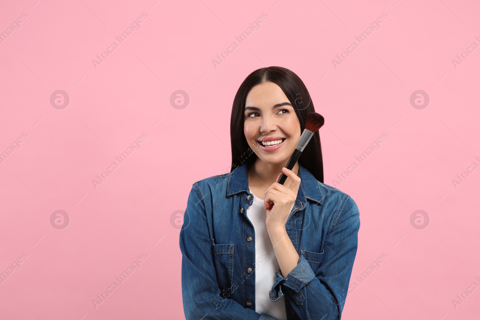 Photo of Beautiful woman with makeup brush on pink background. Space for text