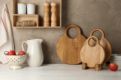 Photo of Wooden cutting boards, kitchen utensils and apples on white table