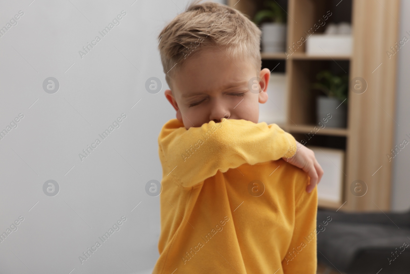 Photo of Sick boy coughing at home. Cold symptoms