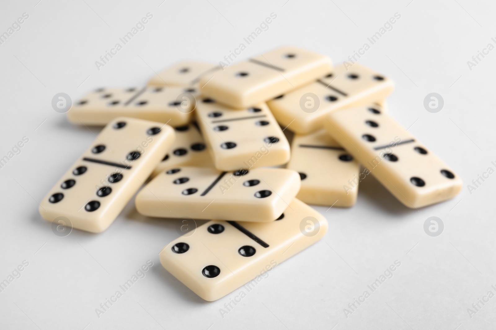 Photo of Pile of domino tiles on white background