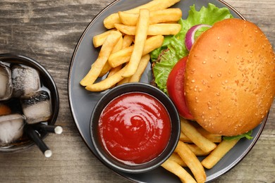 French fries, tasty burger, sauce and drink on wooden table, flat lay