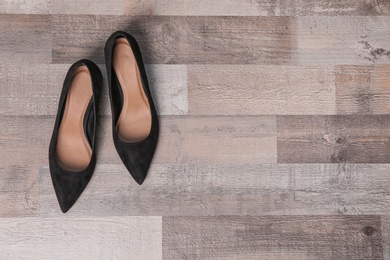 Pair of female shoes on wooden background, top view