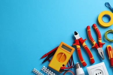 Flat lay composition with electrician's tools and accessories on light blue background, space for text