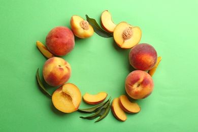 Photo of Flat lay composition with fresh peaches on green background. Space for text