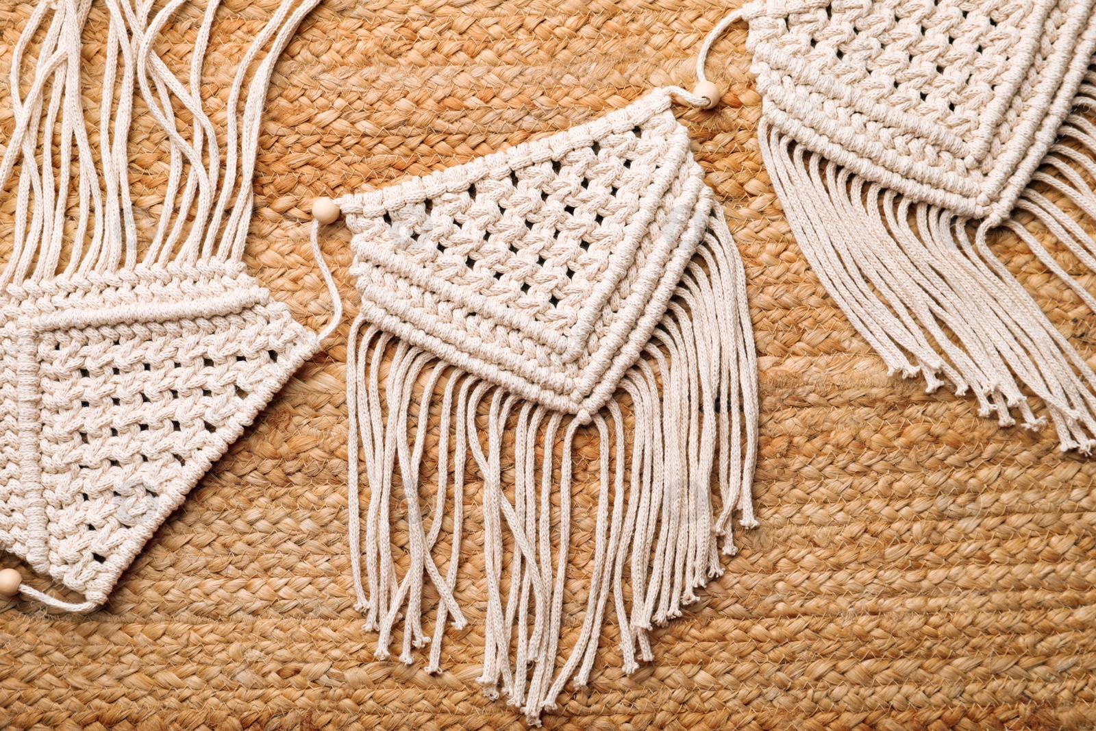 Photo of Large macrame on wicker straw background, flat lay