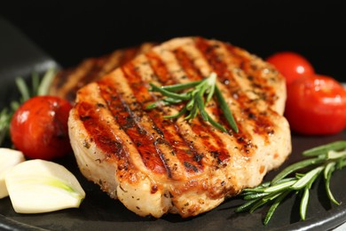 Photo of Delicious grilled pork steaks with spices on platter, closeup