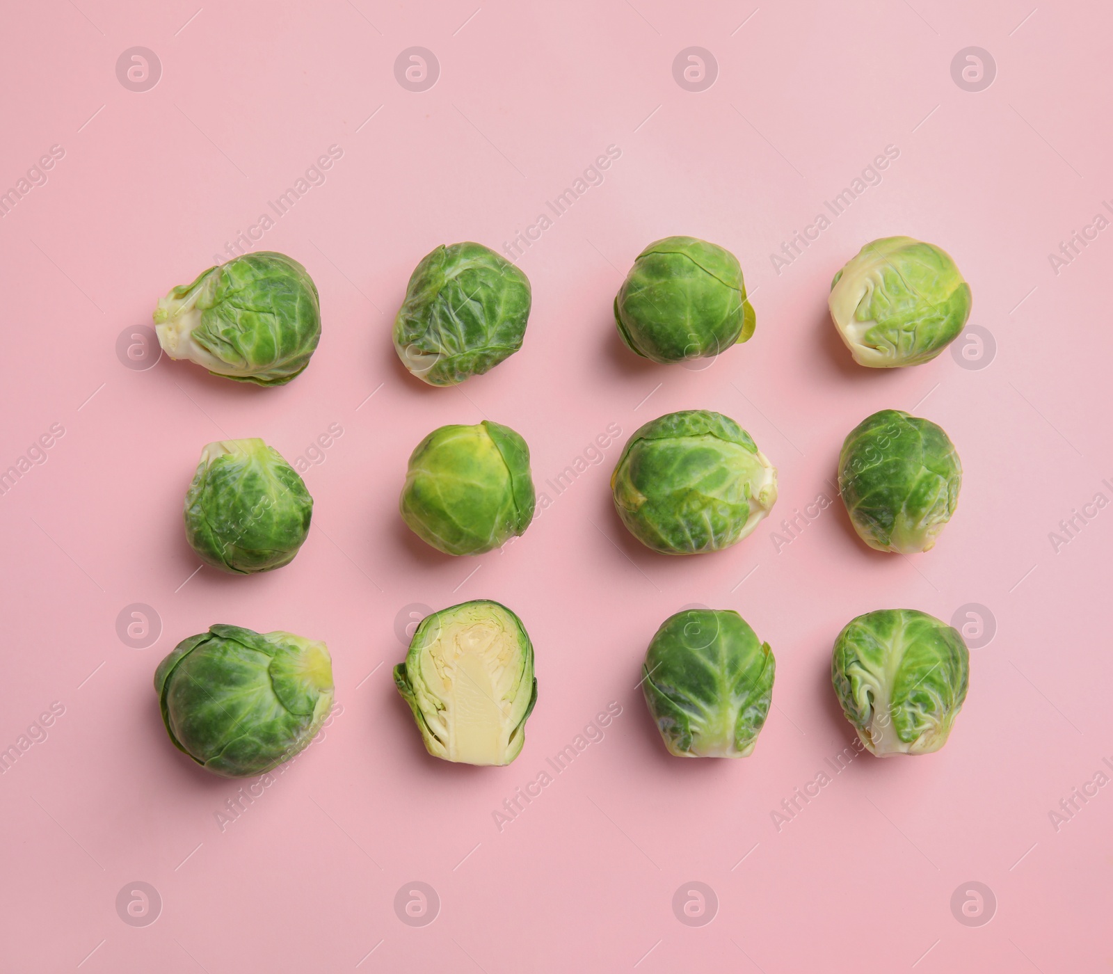 Photo of Fresh Brussels sprouts on pink background, flat lay