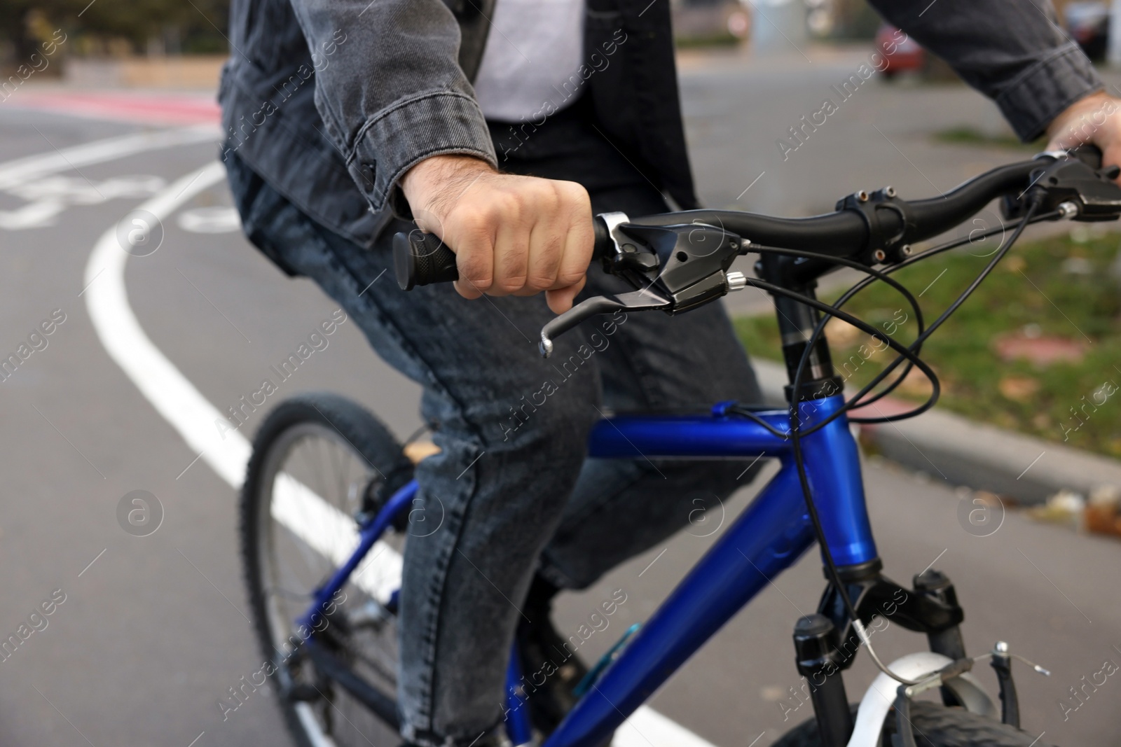 Photo of Man riding bicycle on lane in city, closeup