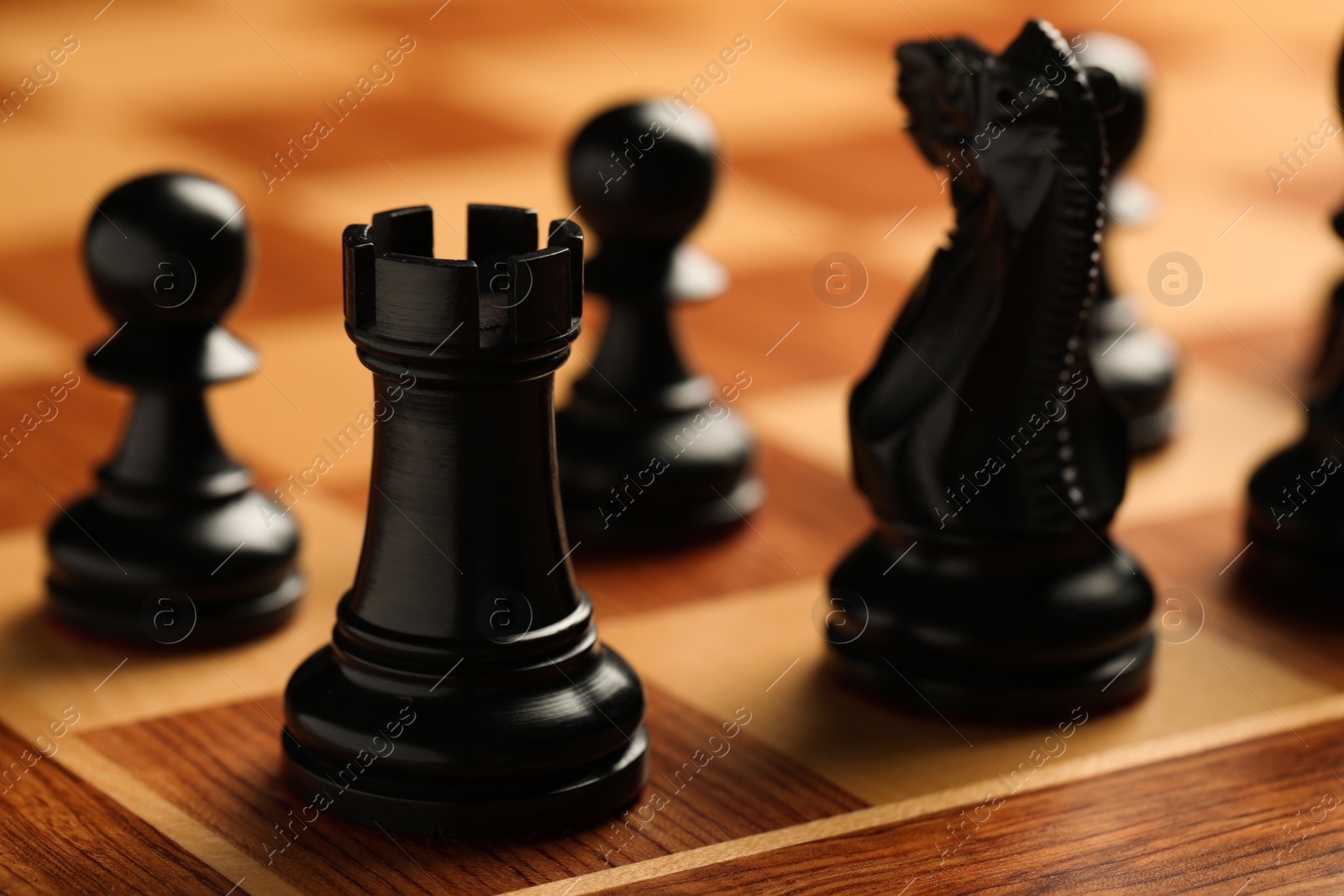 Photo of Wooden chessboard with game pieces, closeup view