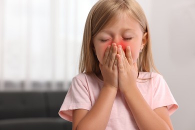 Photo of Suffering from allergy. Little girl sneezing at home, space for text