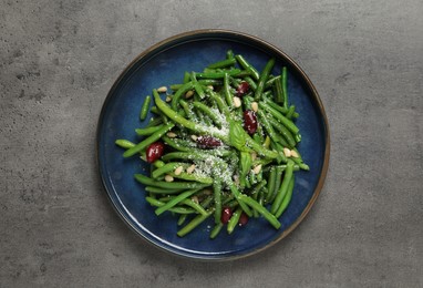 Photo of Plate of tasty salad with green beans on grey table, top view