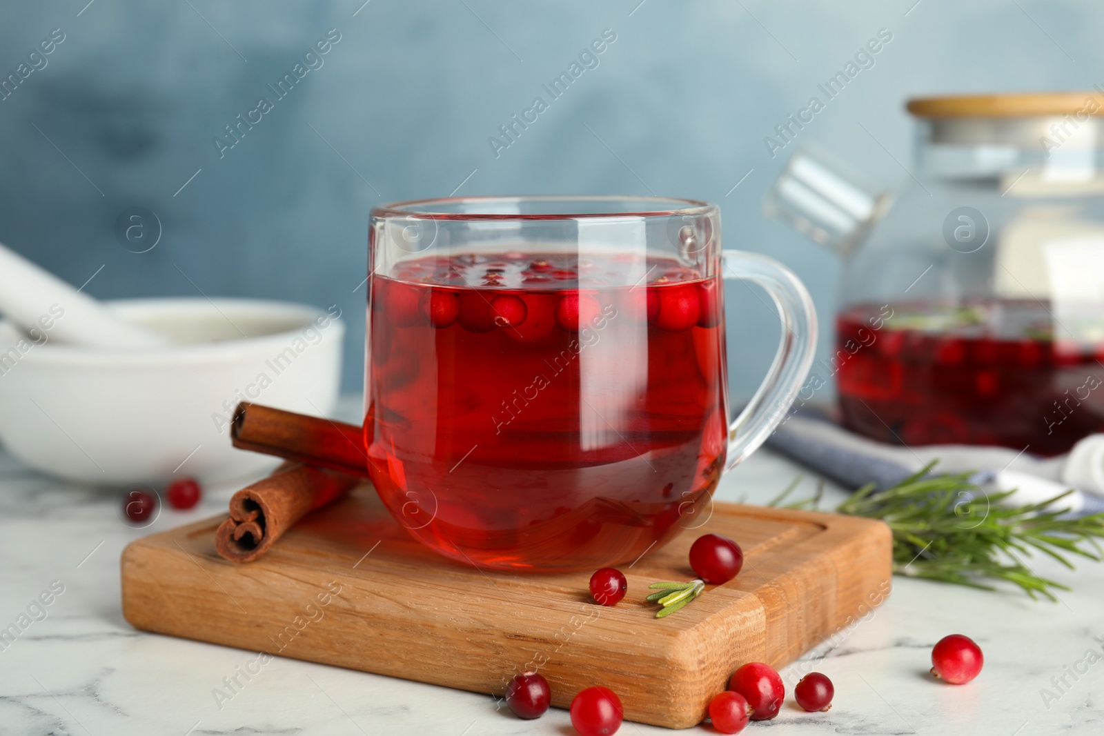 Photo of Tasty hot cranberry tea and fresh ingredients on white marble table