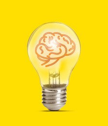 Image of Lamp bulb with human brain inside on yellow background. Idea generation