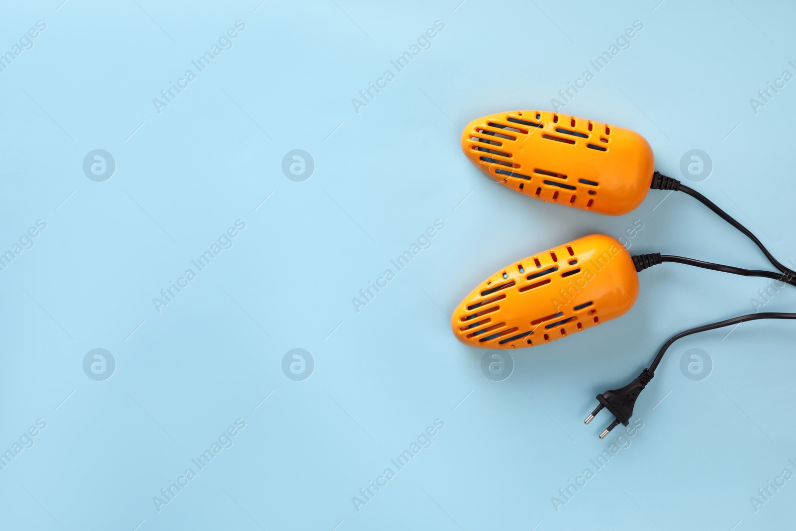 Photo of Modern electric shoe dryer on light blue background, top view. Space for text