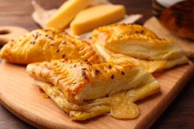 Fresh delicious puff pastry with cheese on wooden table, closeup