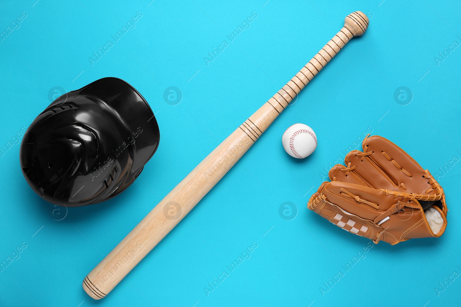 Photo of Baseball glove, bat, ball and batting helmet on light blue background, flat lay