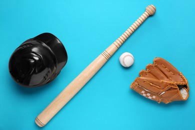Baseball glove, bat, ball and batting helmet on light blue background, flat lay
