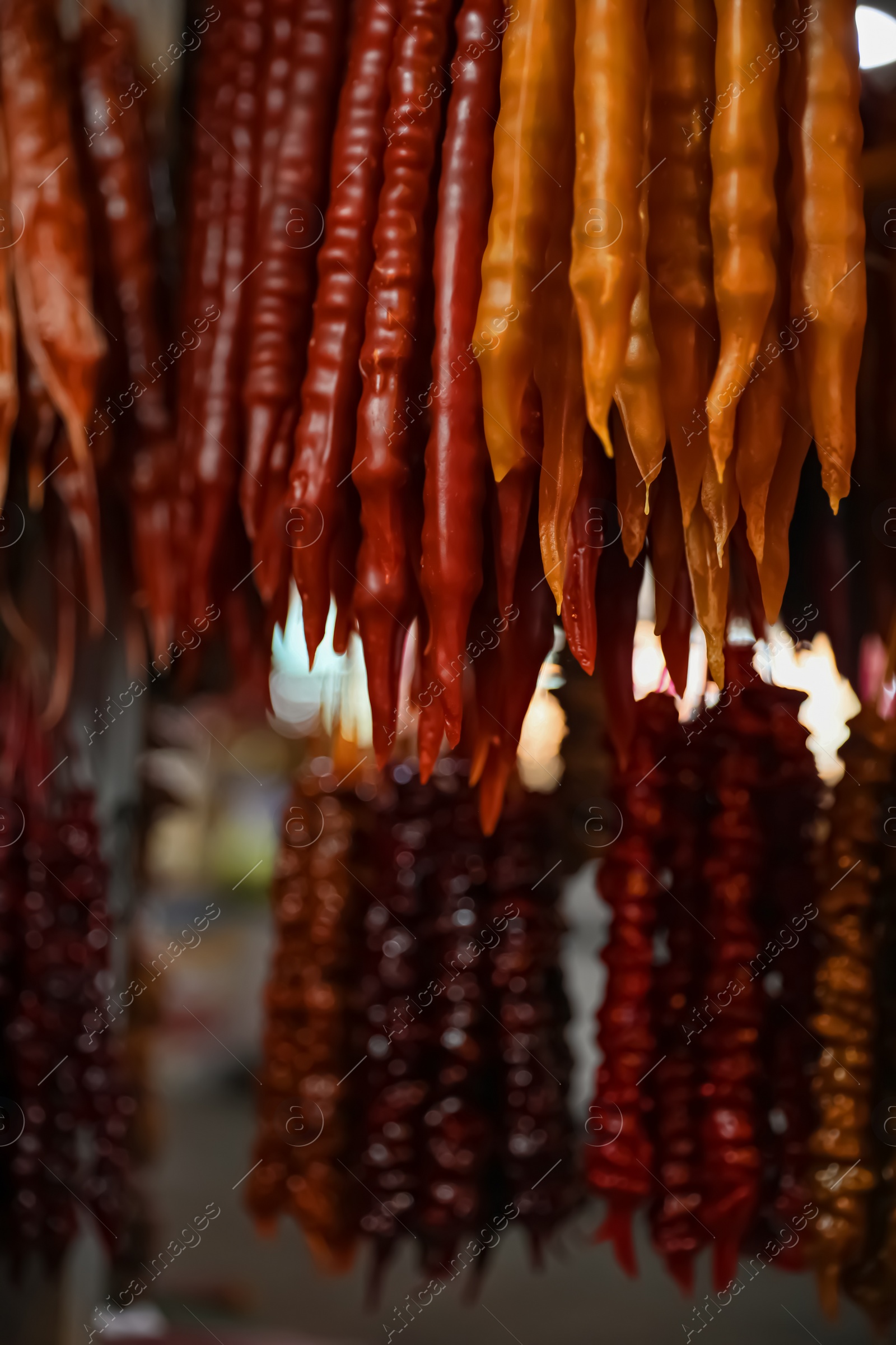 Photo of Bunches of different delicious churchkhelas at market, closeup