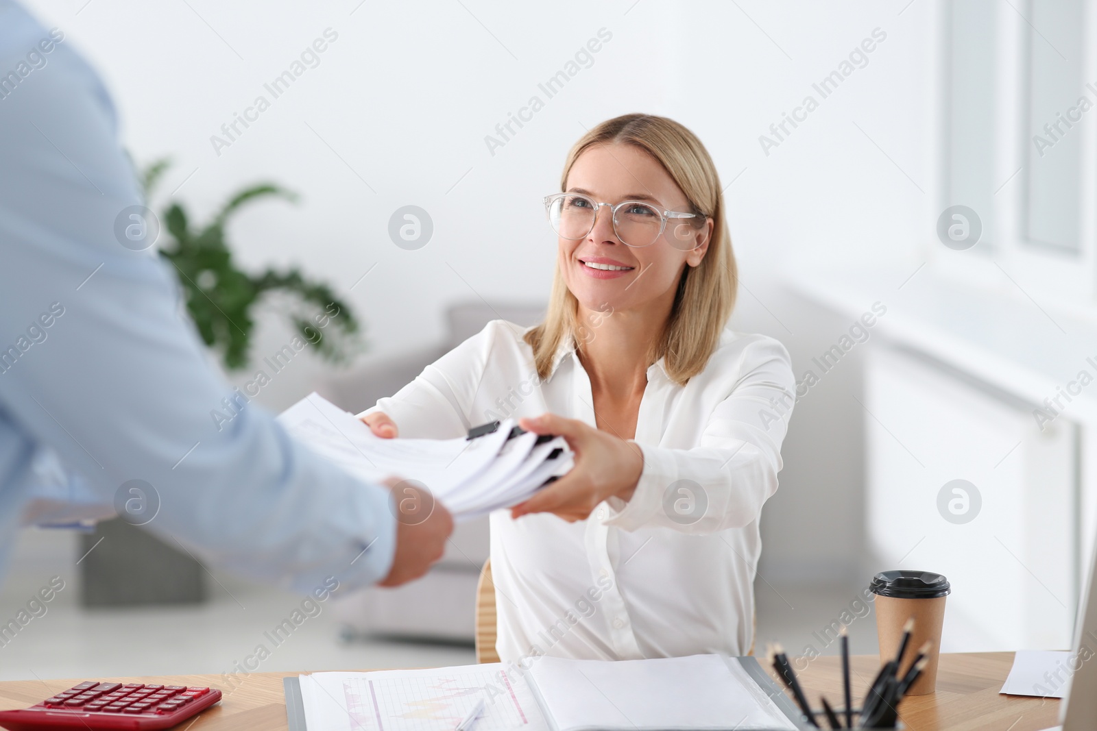 Photo of Man giving documents to colleague in office