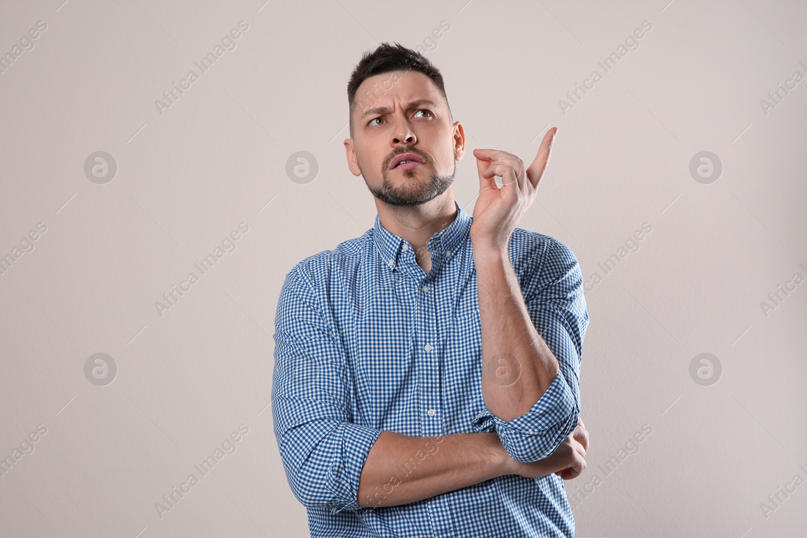 Photo of Emotional man in casual outfit on grey background