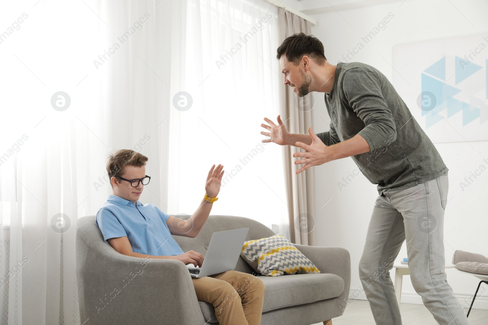 Photo of Father scolding his teenager son at home