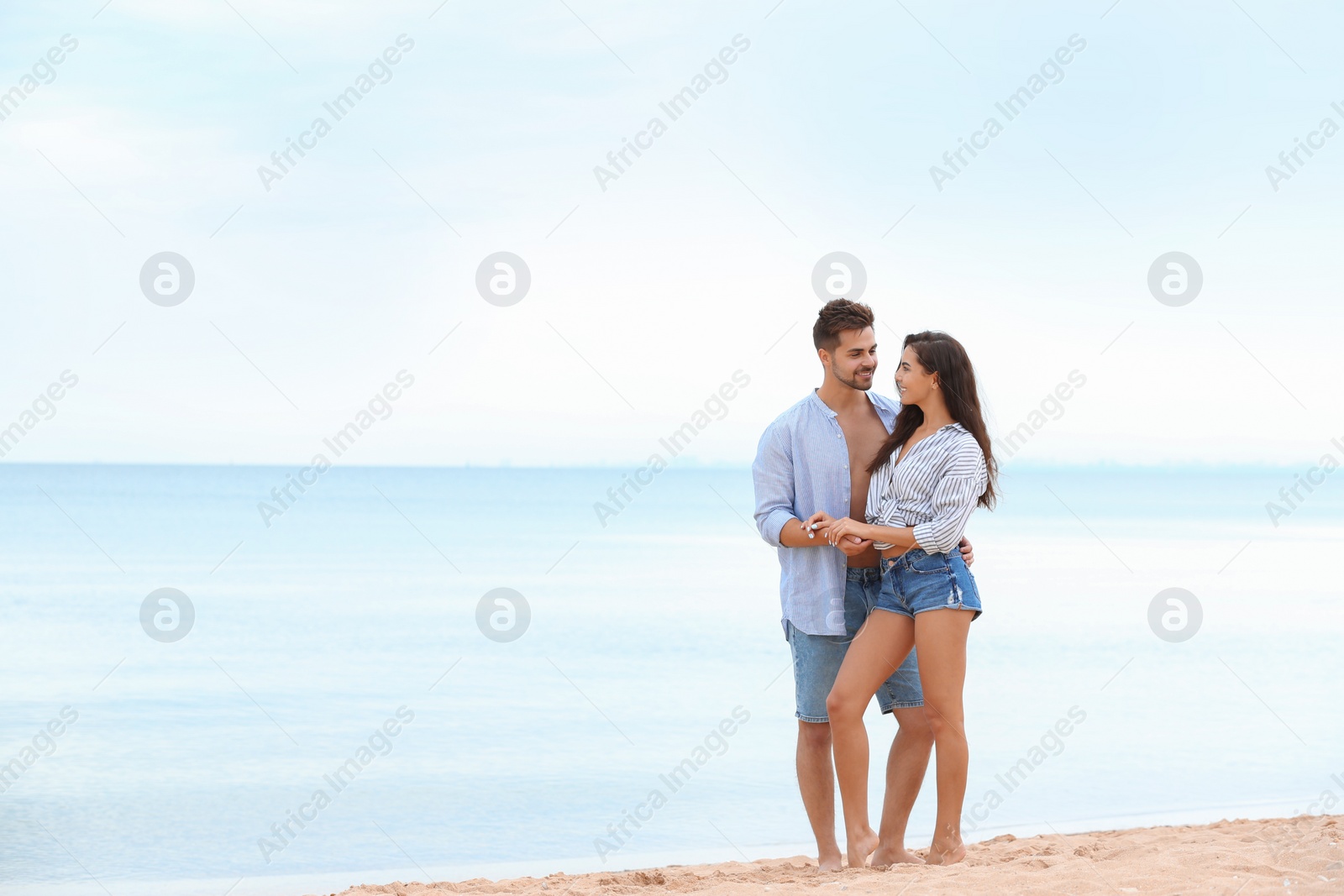 Photo of Happy young couple spending time together on beach