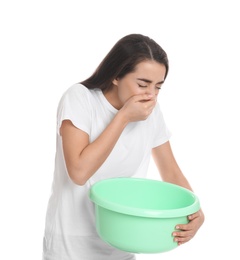 Photo of Young woman with basin suffering from nausea on white background. Food poisoning