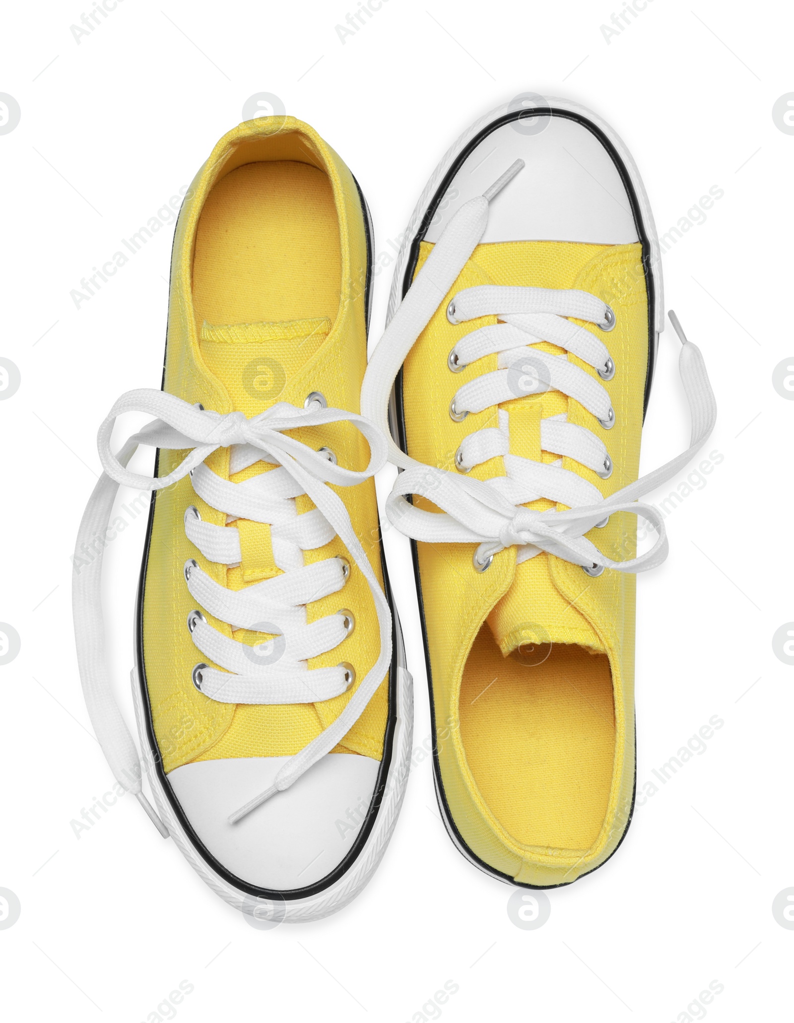 Photo of Pair of yellow classic old school sneakers isolated on white, top view