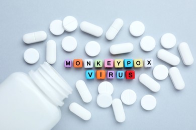 Words Monkeypox Virus made of colorful plastic beads and pills on light background, flat lay