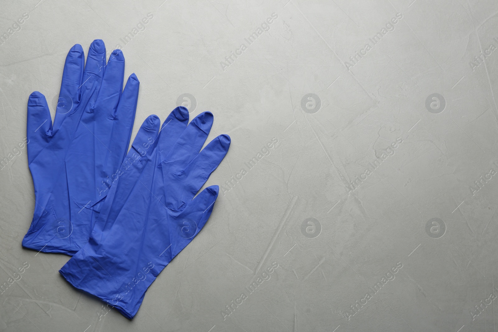 Photo of Pair of medical gloves on light grey background, flat lay. Space for text