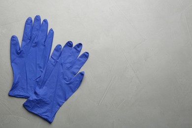 Photo of Pair of medical gloves on light grey background, flat lay. Space for text