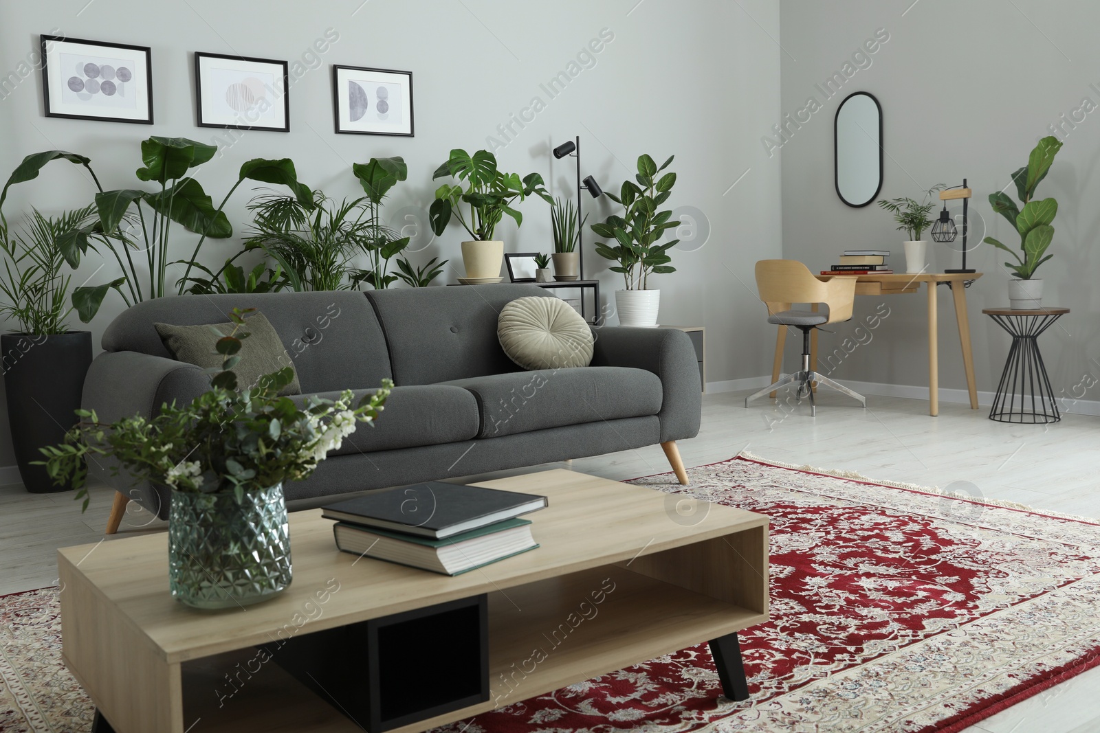 Photo of Cozy room interior with stylish furniture, houseplants and decor elements