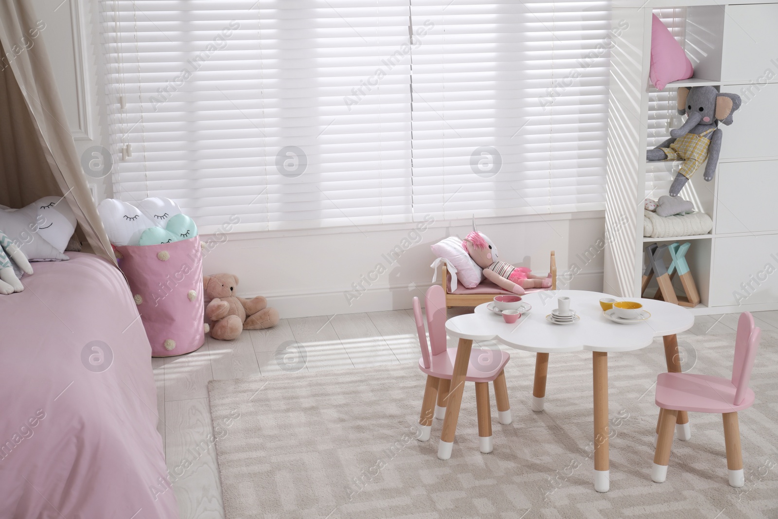 Photo of Cute child's room interior with toys and modern furniture