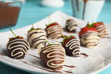 Photo of Plate with chocolate covered strawberries on table, closeup