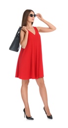 Photo of Young woman wearing stylish red dress with elegant bag on white background